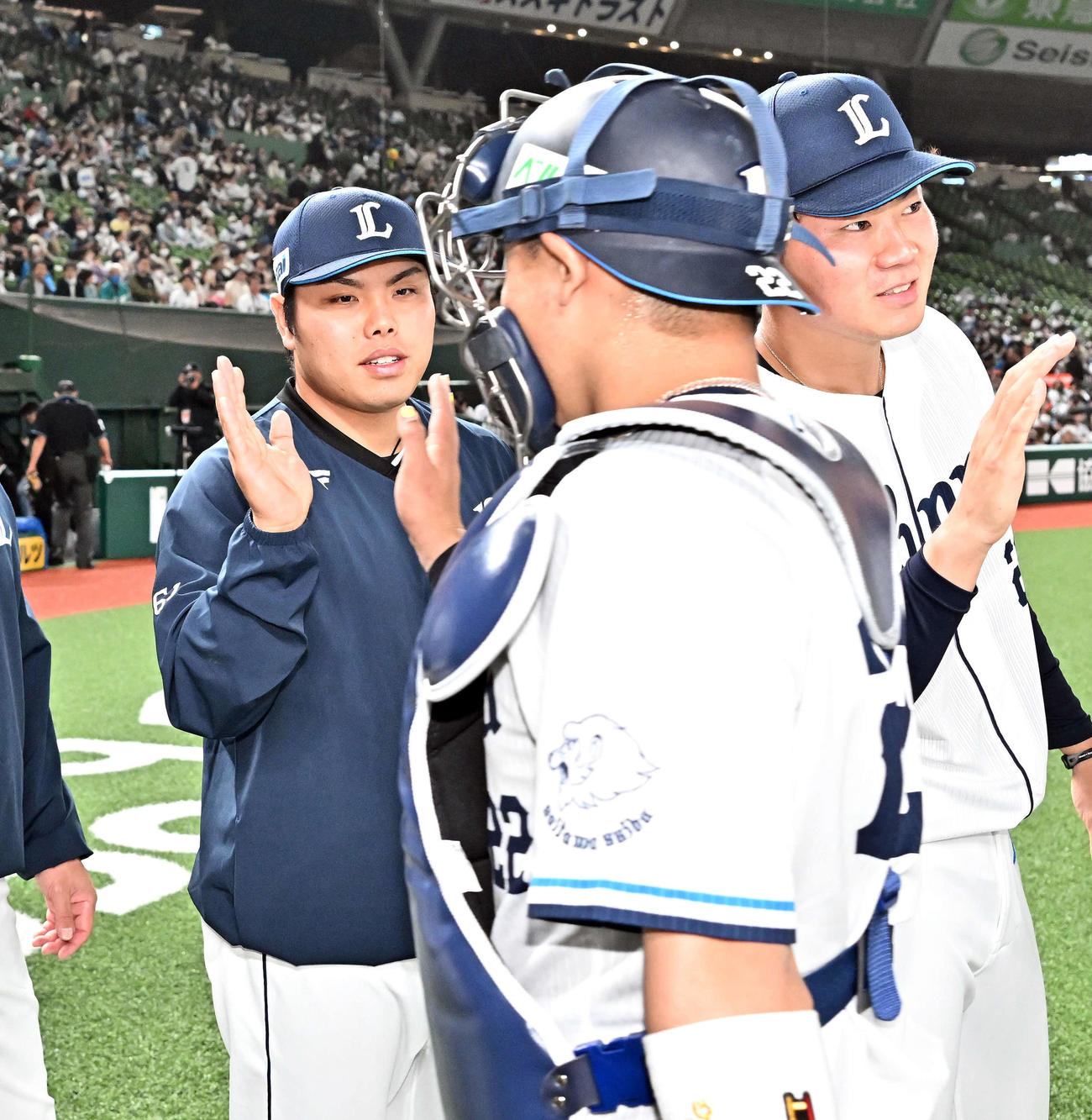 西武対ロッテ　試合後、勝利投手の西武平良（後方左）は捕手古賀とタッチを交わす（撮影・滝沢徹郎）