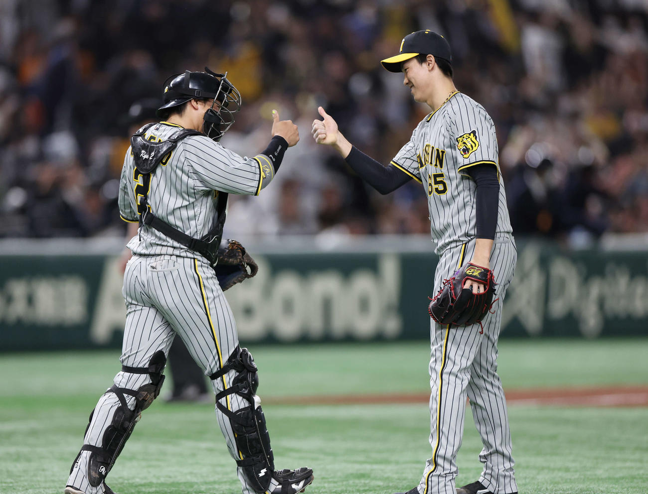 巨人対阪神　巨人に勝利し、親指を立てタッチを交わす阪神梅野（左）と湯浅（撮影・宮地輝）