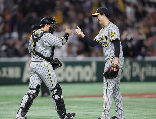 巨人対阪神 巨人に勝利し、親指を立てタッチを交わす阪神梅野(左)と湯浅(撮影・宮地輝)
