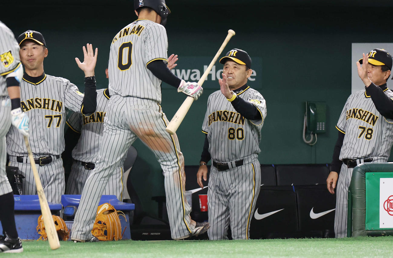 巨人対阪神　10回表阪神1死三塁、近本が勝ち越し左適時打を放ち、生還した木浪（中央左）を迎える岡田監督（中央右）（撮影・宮地輝）