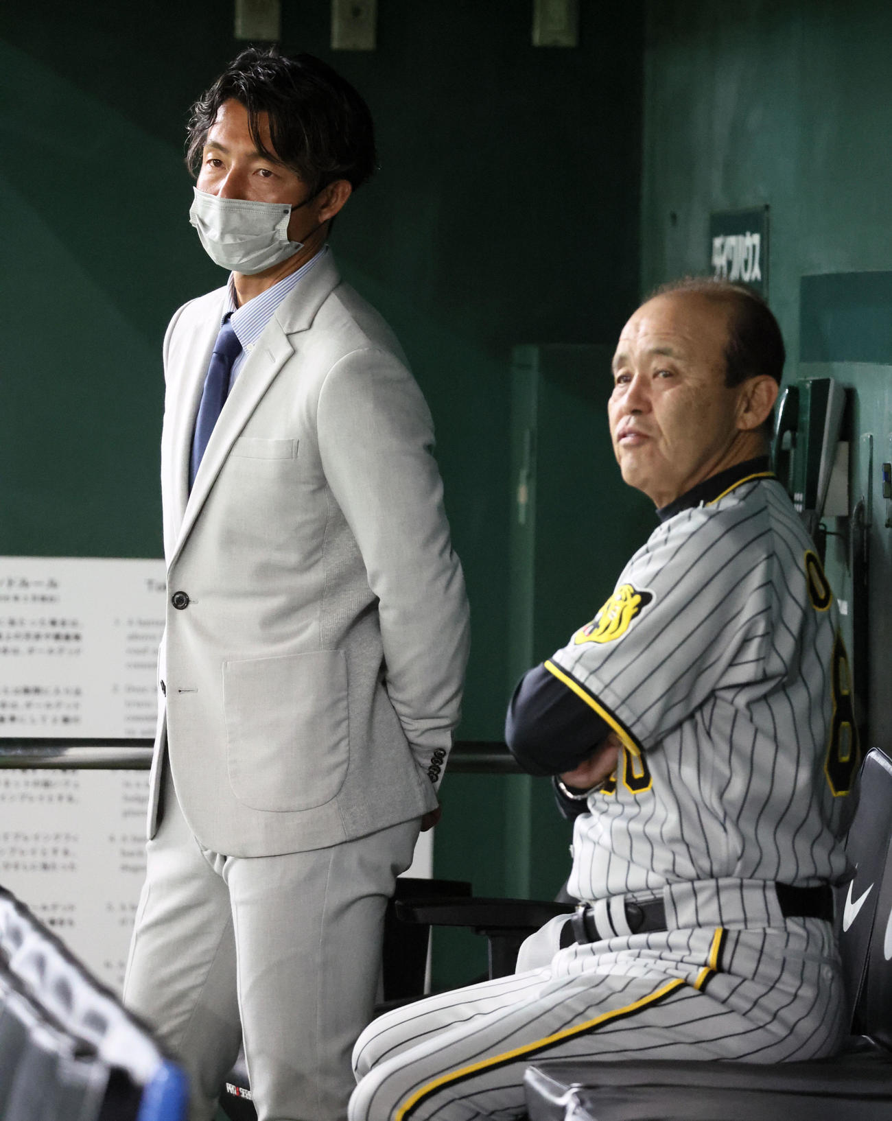 巨人対阪神　ベンチで日刊スポーツ評論家の鳥谷敬氏（左）と話す岡田監督（撮影・加藤哉）