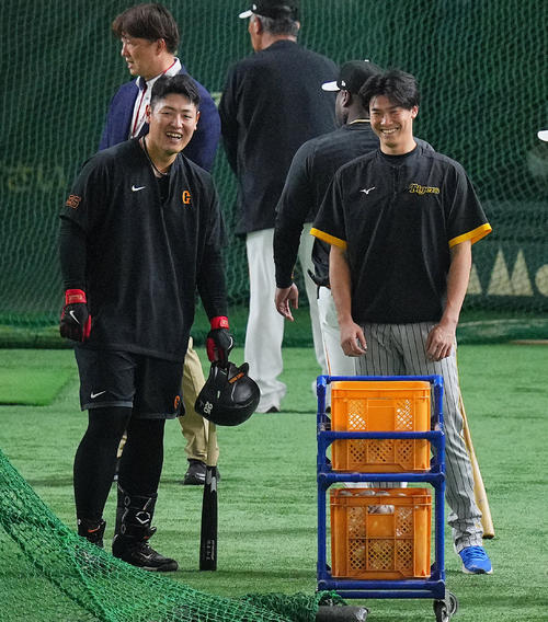巨人対阪神　試合前、談笑する巨人岡本和（左）と阪神湯浅（撮影・垰建太）