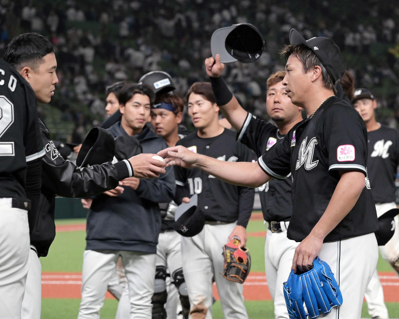 西武対ロッテ　試合後、勝利投手のロッテ西野（左）は益田から記念球を受け取る（撮影・滝沢徹郎）