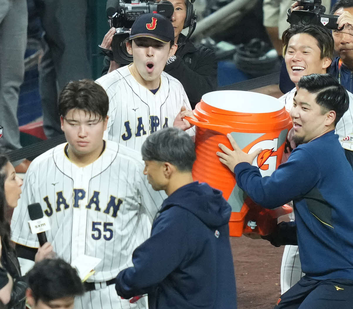 WBC準決勝のメキシコ戦でサヨナラ打を放った村上（手前）にスポーツドリンクを持ち近づく佐々木朗と山本（後方右）（2023年３月撮影）