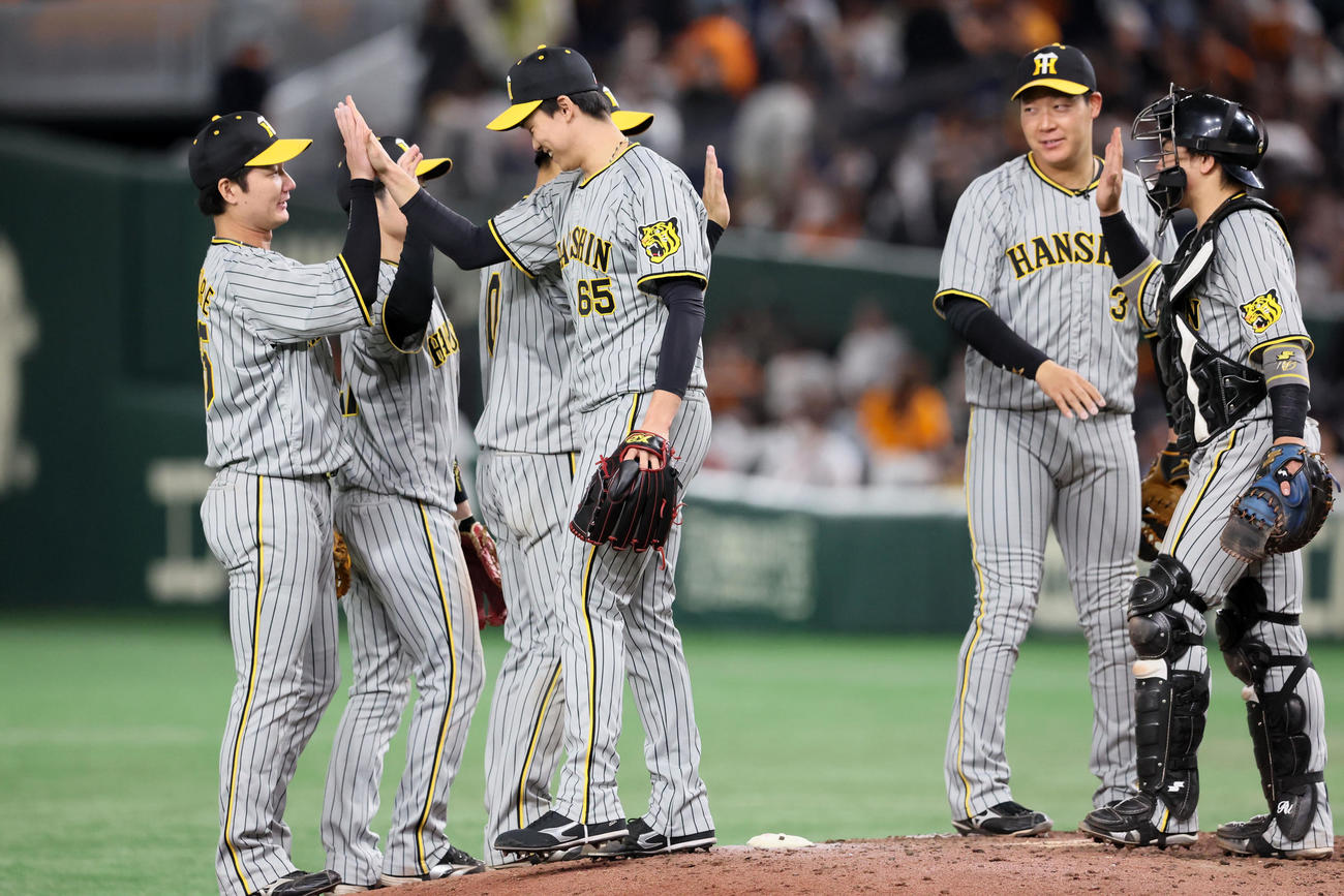 巨人対阪神　巨人に勝利しマウンドでタッチする渡辺諒（左）と湯浅ら阪神ナイン（撮影・加藤哉）