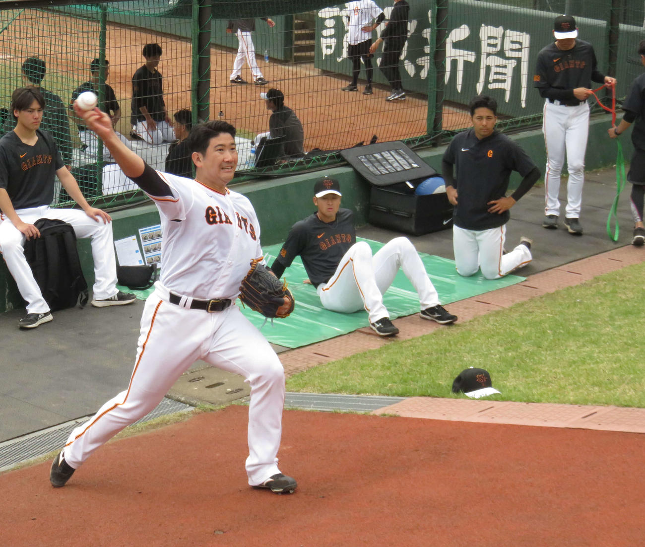 坂道で投球練習をする巨人菅野（手前）