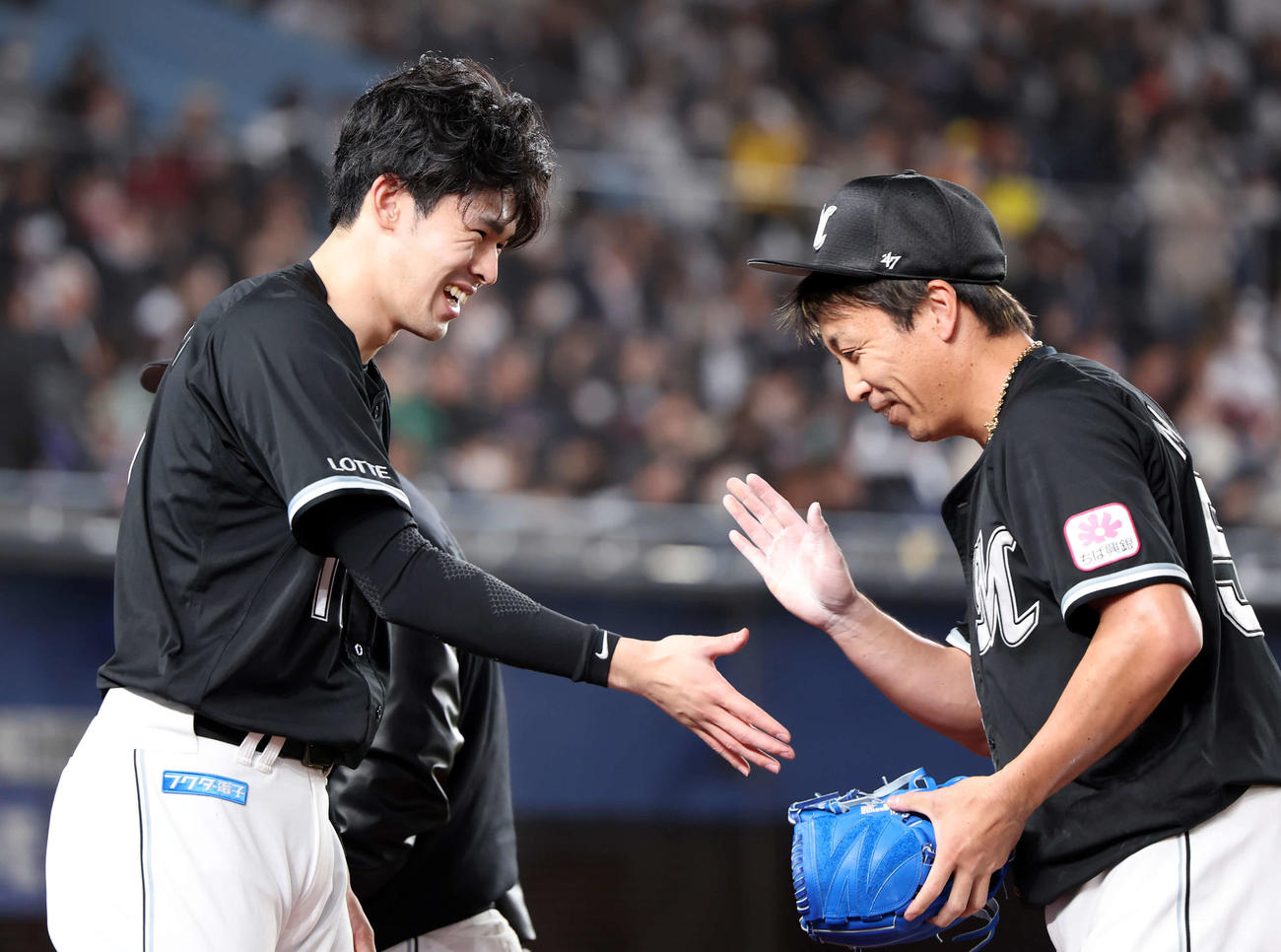 ロッテ対オリックス　8回表オリックスの攻撃を抑えた益田（右）を笑顔で迎える佐々木朗（撮影・浅見桂子）