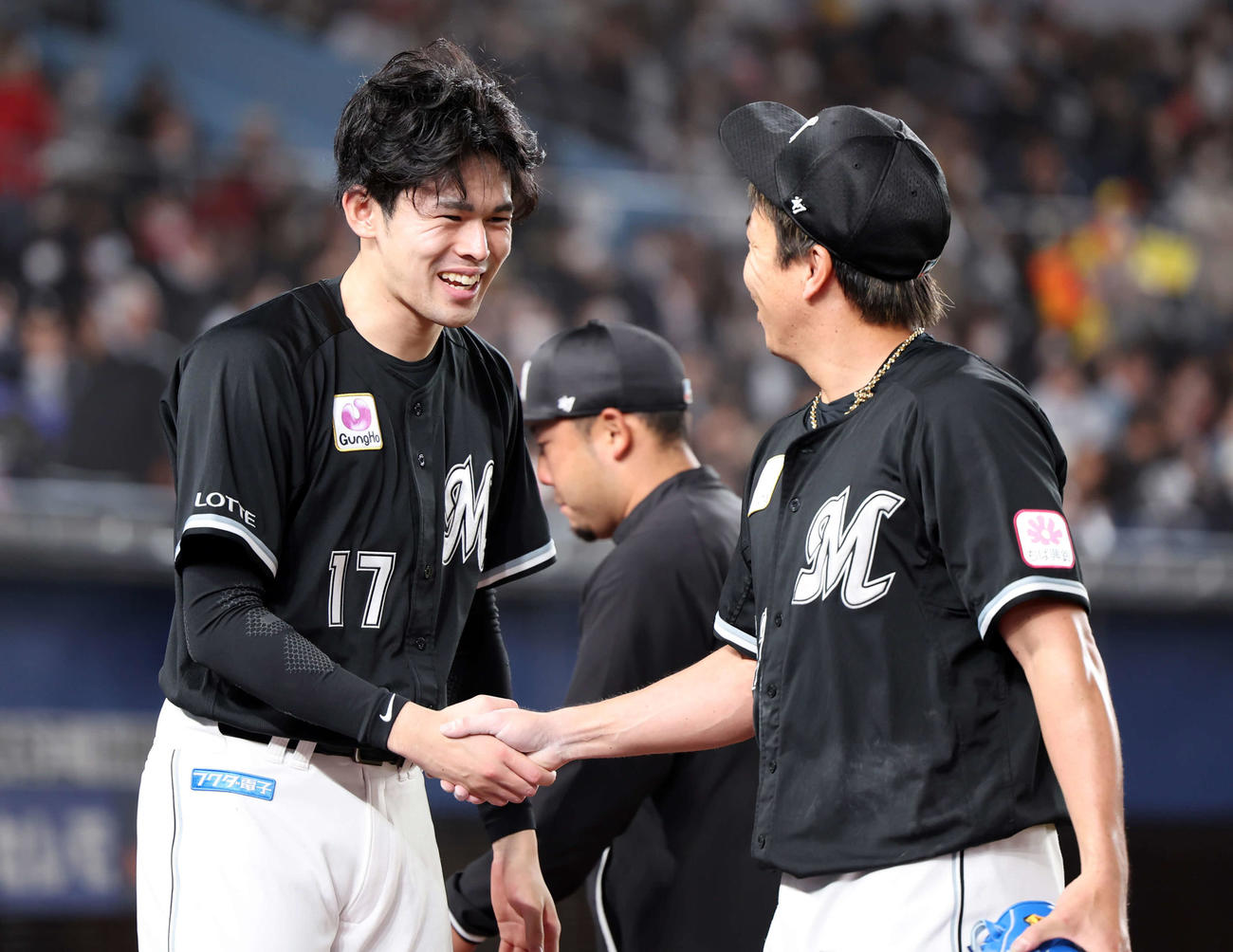 ロッテ対オリックス　8回表オリックスの攻撃を抑えた益田（右）と笑顔で握手する佐々木朗（撮影・浅見桂子）