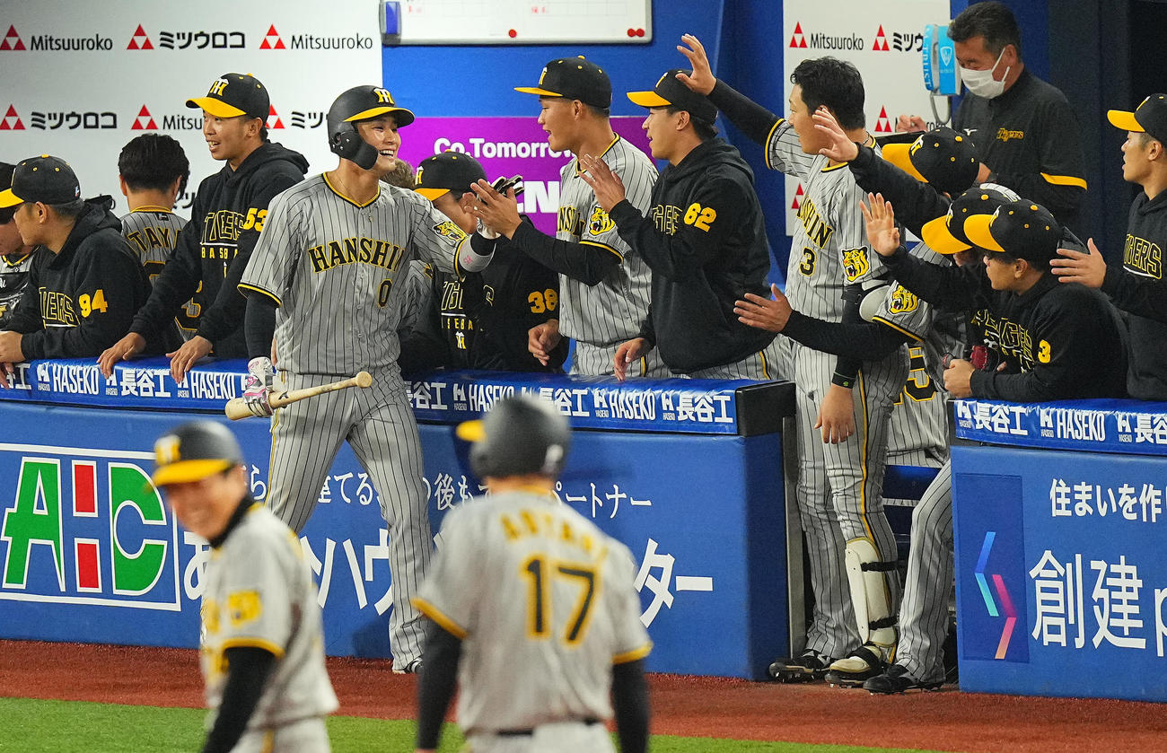 DeNA対阪神　2回表阪神2死一、二塁、近本の適時打で生還した木浪（左）はナインの出迎えを受ける（撮影・垰建太）