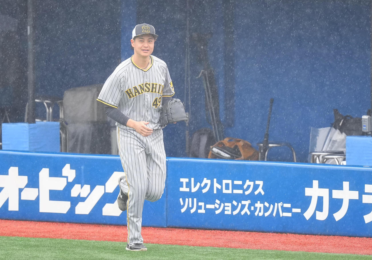 DeNA対阪神　雨天中止となり雨の中、走ってブルペンへ向かう阪神大竹（撮影・垰建太）