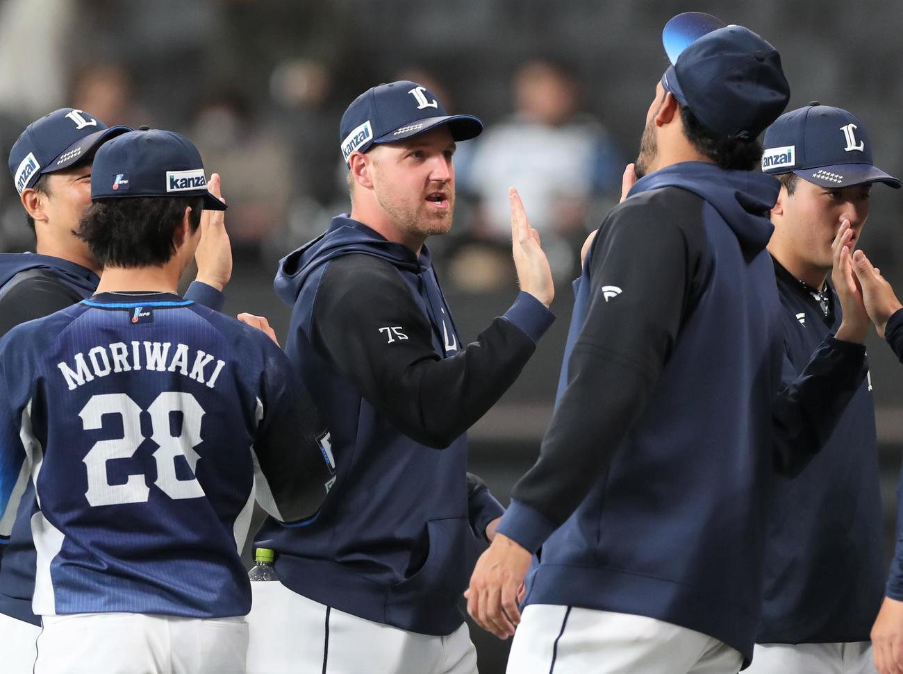 日本ハム対西武　試合後、ナインとタッチするエンス（撮影・黒川智章）