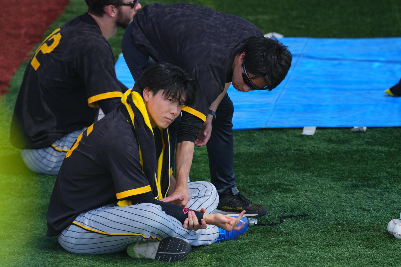 DeNA対阪神　試合前、トレーナーの指導で右手を動かす阪神湯浅（撮影・垰建太）