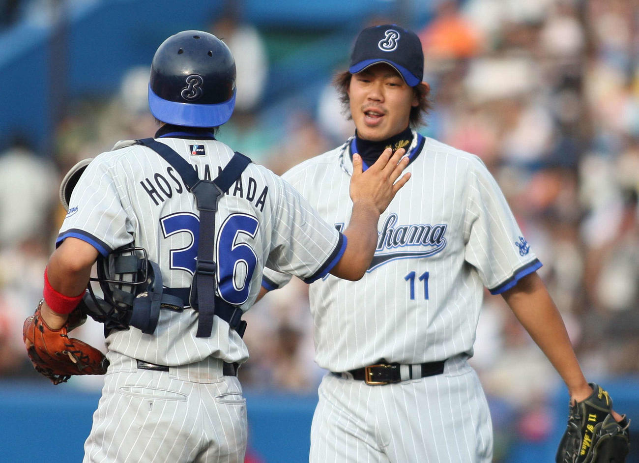 9回裏を無失点に抑え、2日連続のセーブを決めた横浜山口俊（右）は細山田武史と勝利のタッチをする（2009年7月12日撮影）