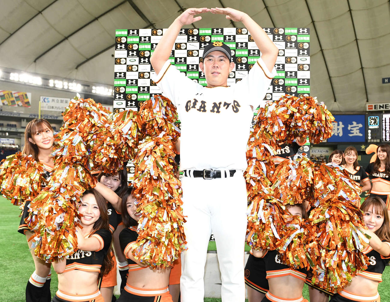 巨人対広島　チームビーナスの人文字「M6」を背に丸ポーズを決める巨人山口（2019年9月撮影）
