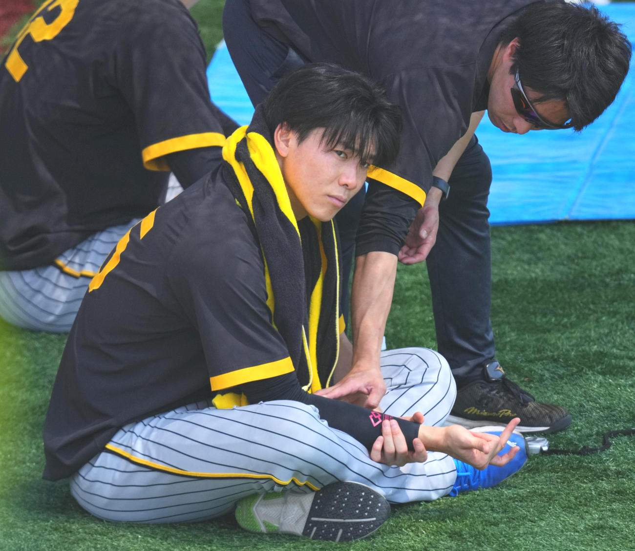 16日、トレーナーの指導で右手を動かす阪神湯浅京己