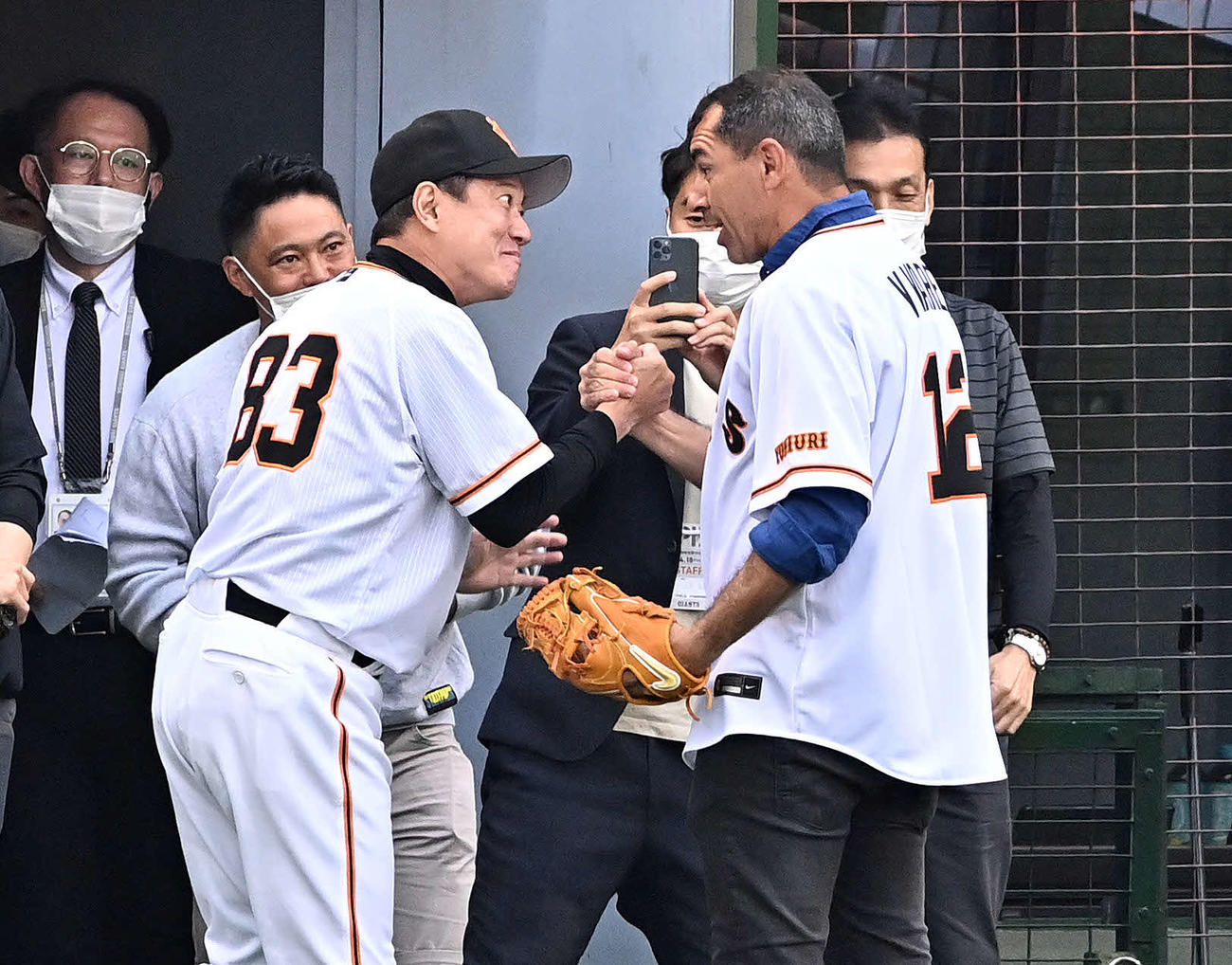 巨人対DeNA　始球式を終えたV・ファーレン長崎のファビオ・カリーレ監督（右）と握手を交わす巨人原監督（撮影・滝沢徹郎）