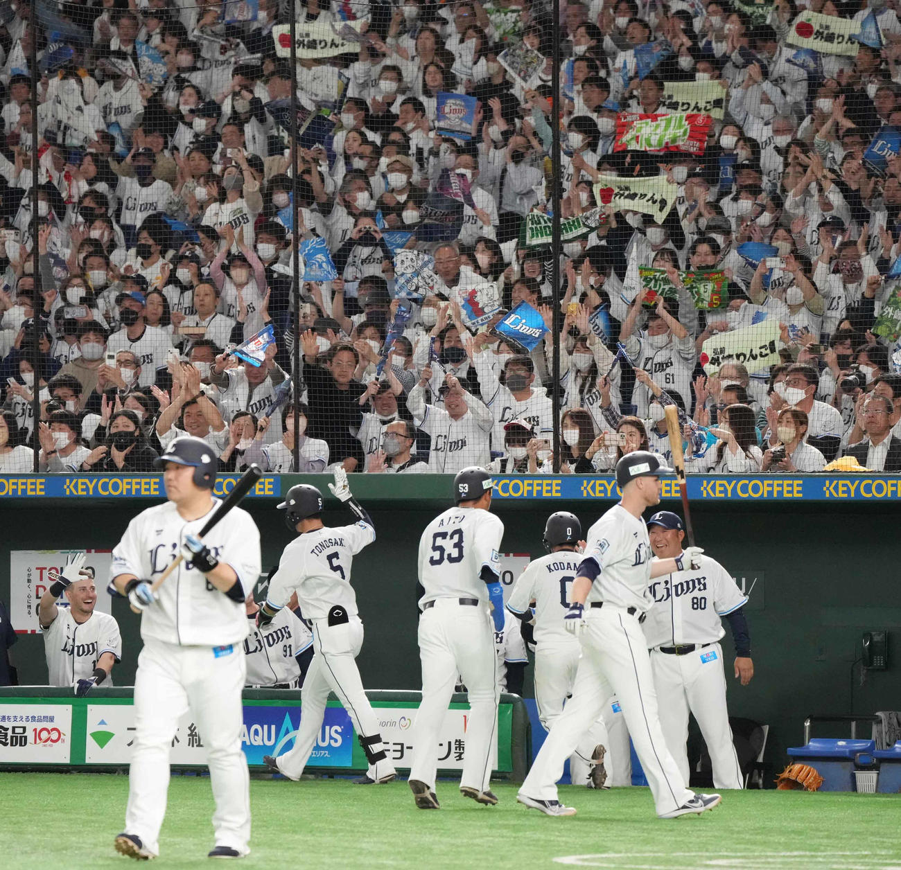 西武対ソフトバンク　5回裏西武1死二、三塁、外崎（左から3人目）は左越えに2打席連続の3点本塁打を放ちベンチの祝福を受ける。超満員のスタンドには「外崎りんご園」と書かれたタオルが見られた（撮影・小沢裕）