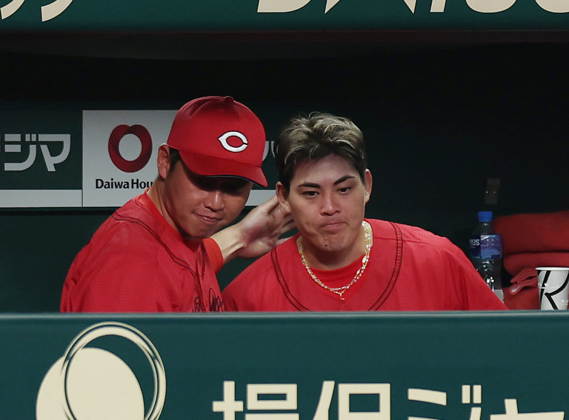 阪神対広島　7回裏を投げ終え、ベンチで広島新井監督（左）に声を掛けられる九里（撮影・前田充）