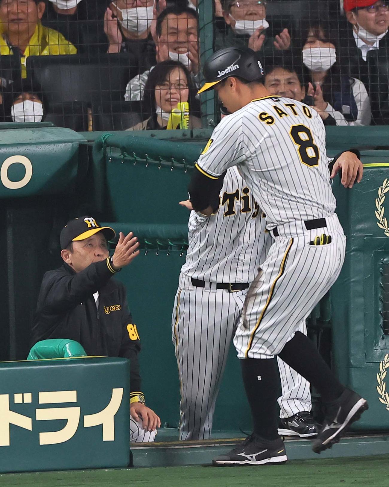 阪神対広島　5回裏阪神無死一、三塁、坂本の右犠飛で生還した佐藤輝（右）を出迎える岡田監督（撮影・上田博志）