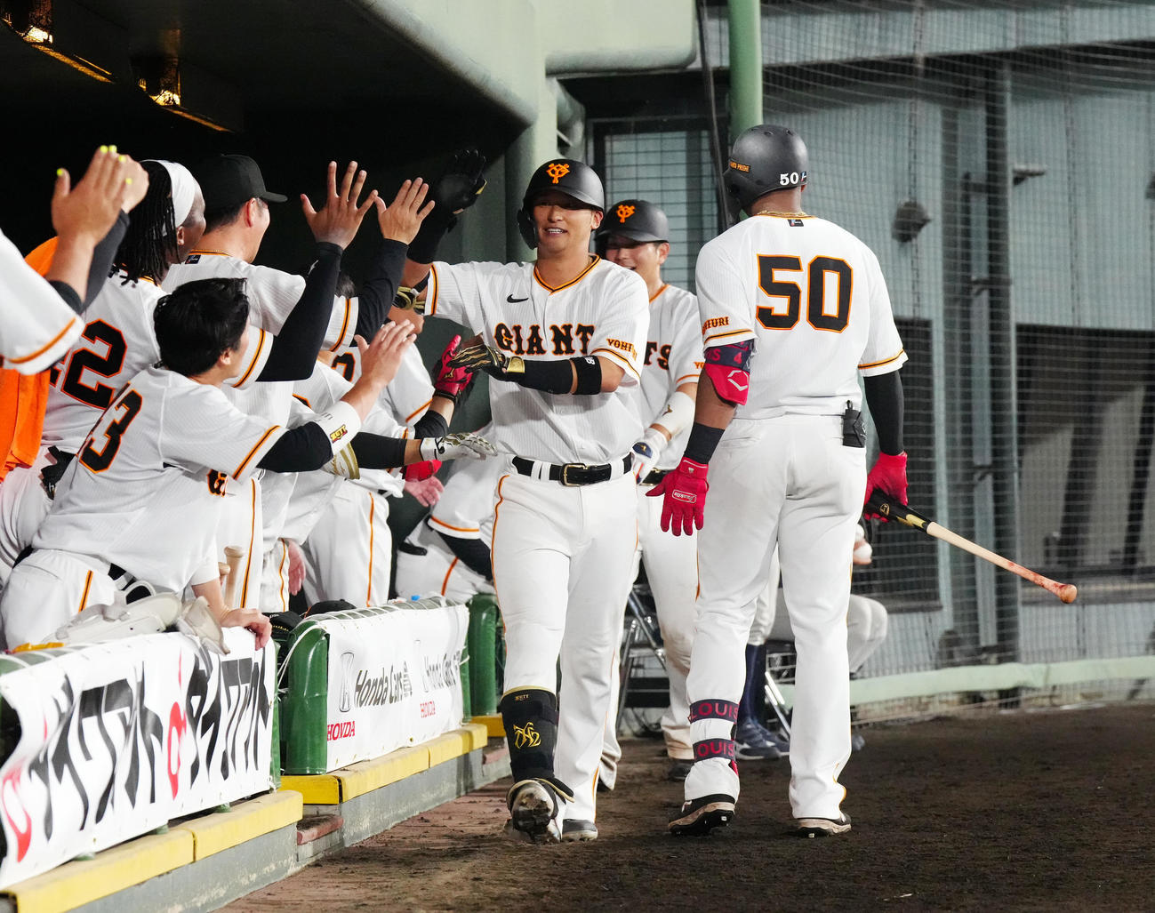 巨人対DeNA 7回裏巨人無死一塁、2点本塁打を放ち、チームメートとタッチを交わす吉川（中央）（撮影・江口和貴）