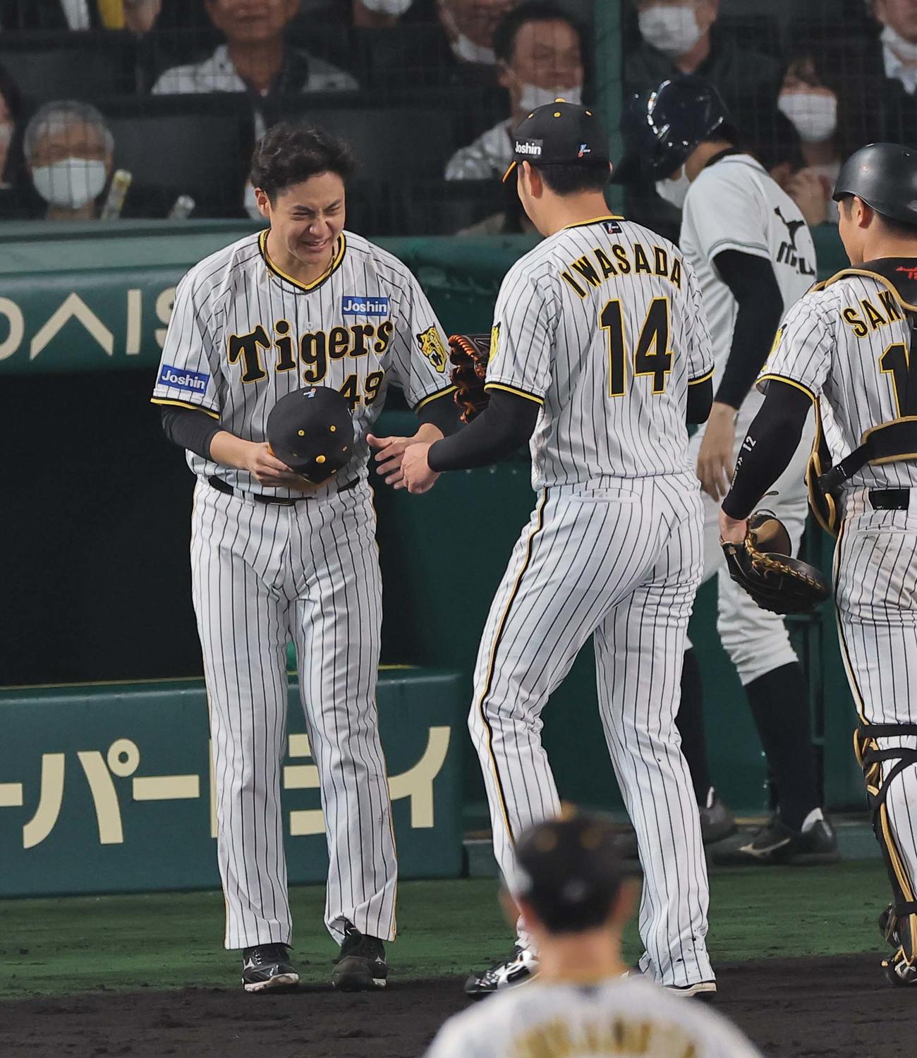 阪神対広島　7回途中から登板した2番手岩貞（右）を笑顔で出迎える大竹（撮影・上田博志）