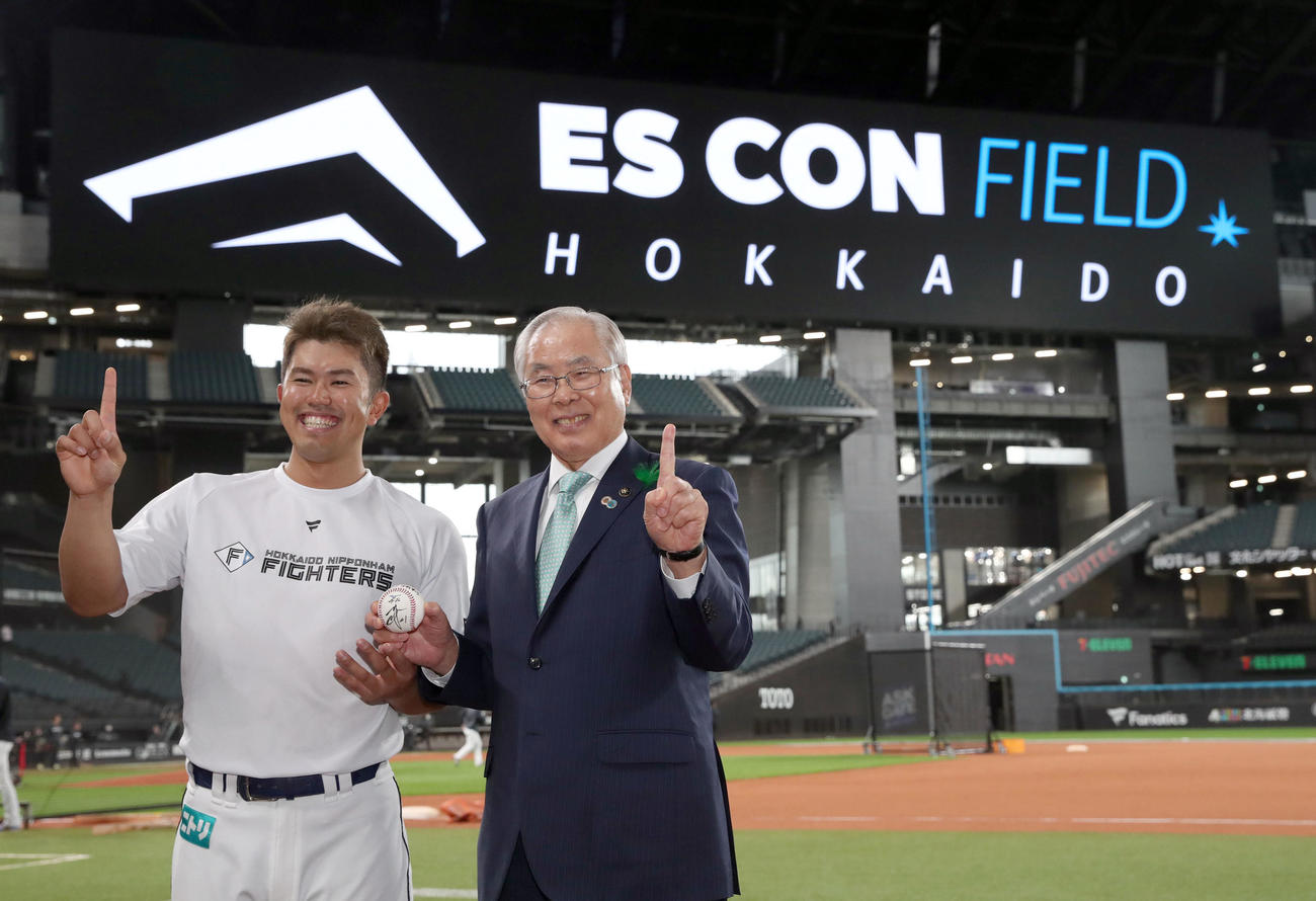 日本ハム対ロッテ　試合前、日本ハム今川からエスコンフィールド北海道オープン戦第1号本塁打記念ボールを手渡され、笑顔で記念撮影に応じる上野北広島市長（撮影・佐藤翔太）