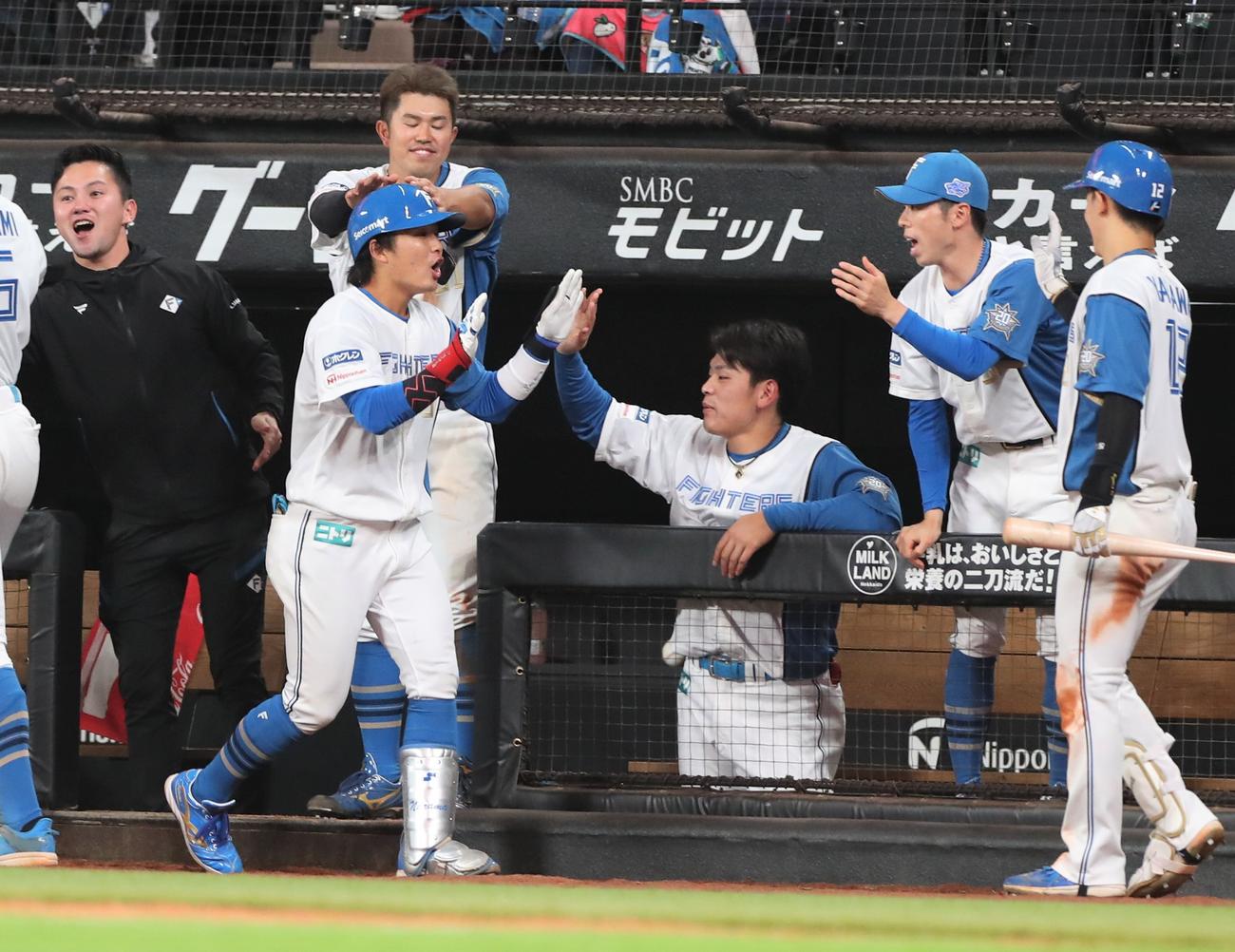 日本ハム対ロッテ　4回裏日本ハム1死三塁、左犠飛を放った奈良間（左）を出迎えるナイン（撮影・黒川智章）