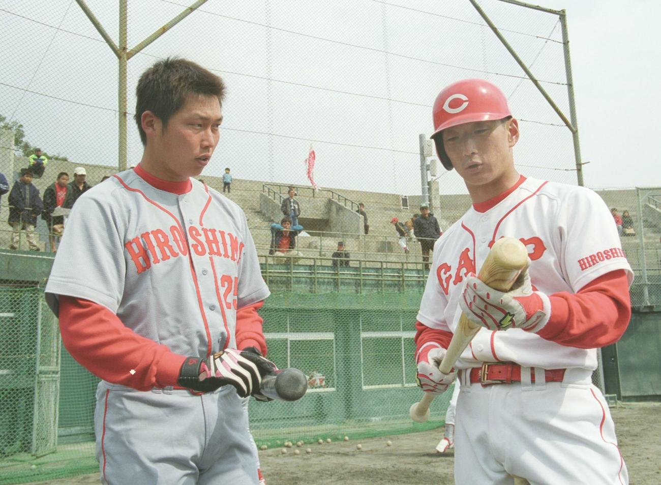 2002年広島春季キャンプ　バットを手に真剣な表情で話し合う新井貴浩（左）と金本知憲（2002年2月12日）