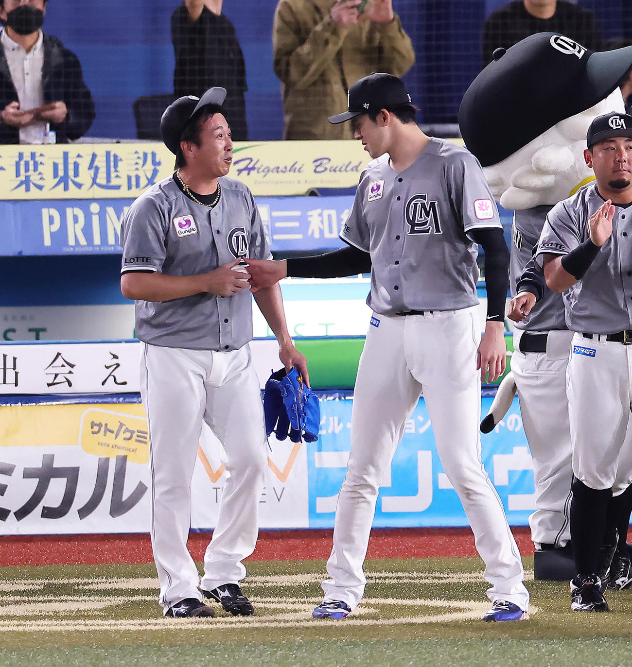 ロッテ対ソフトバンク　ロッテ益田（左）から受け取った勝利球を渡し返す佐々木朗（撮影・足立雅史）