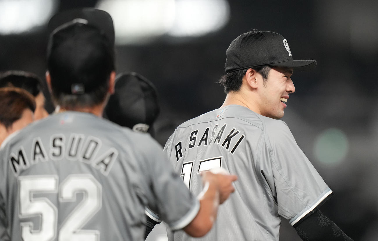 ロッテ対ソフトバンク　益田（手前）からウイニングボールを受け取らず、笑顔のロッテ佐々木朗（撮影・鈴木みどり）