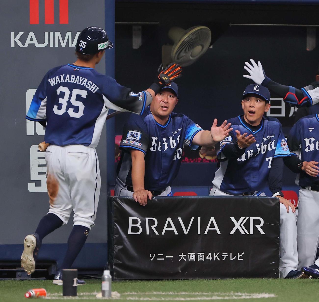 オリックス対西武　1回表西武2死二、三塁、松井監督（右）はマキノンの2点適時二塁打で生還した若林を出迎える（撮影・上田博志）