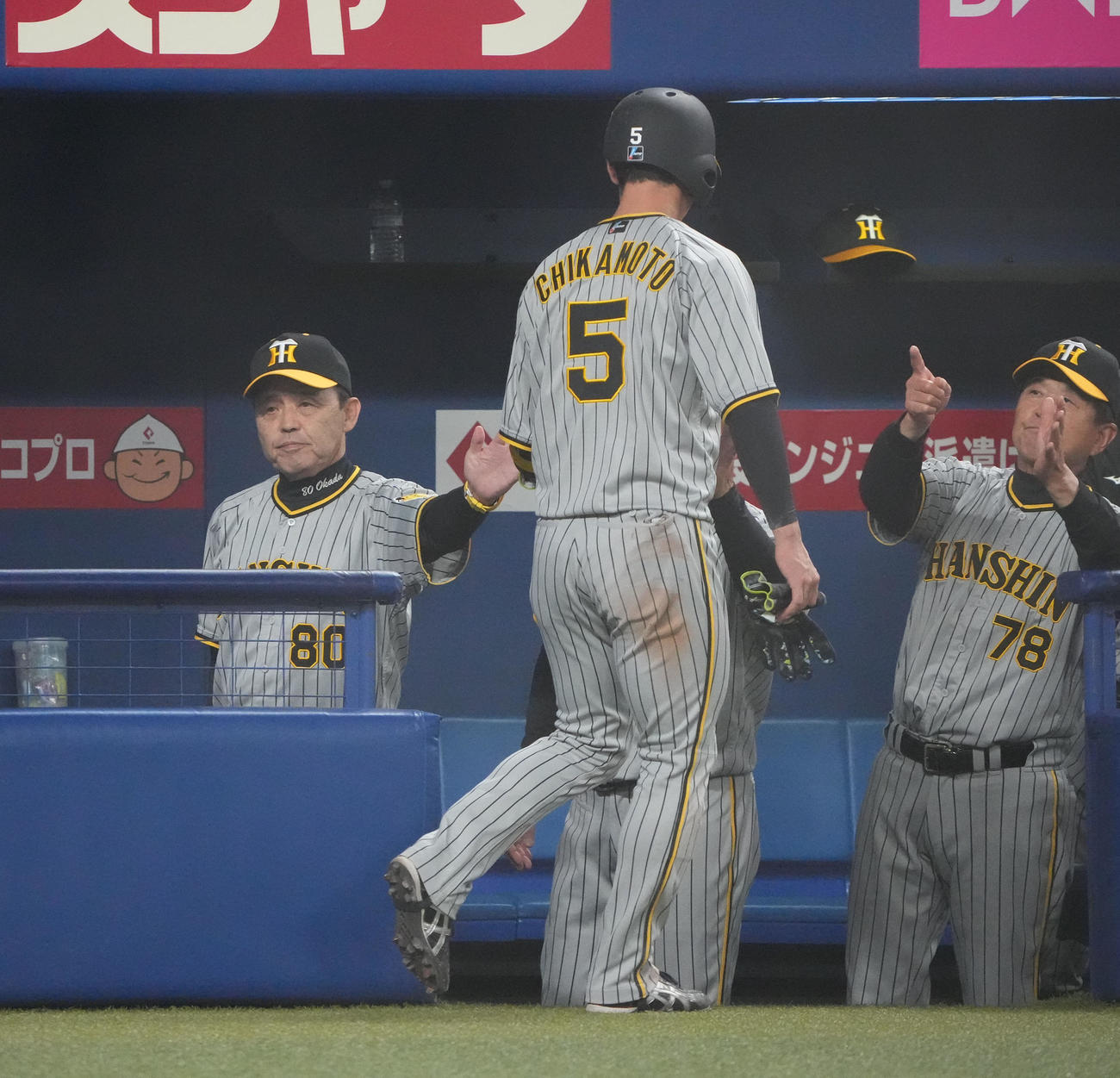 中日対阪神　1回表阪神1死一、三塁、大山の犠飛で生還した近本を迎える岡田監督（左）（撮影・森本幸一）