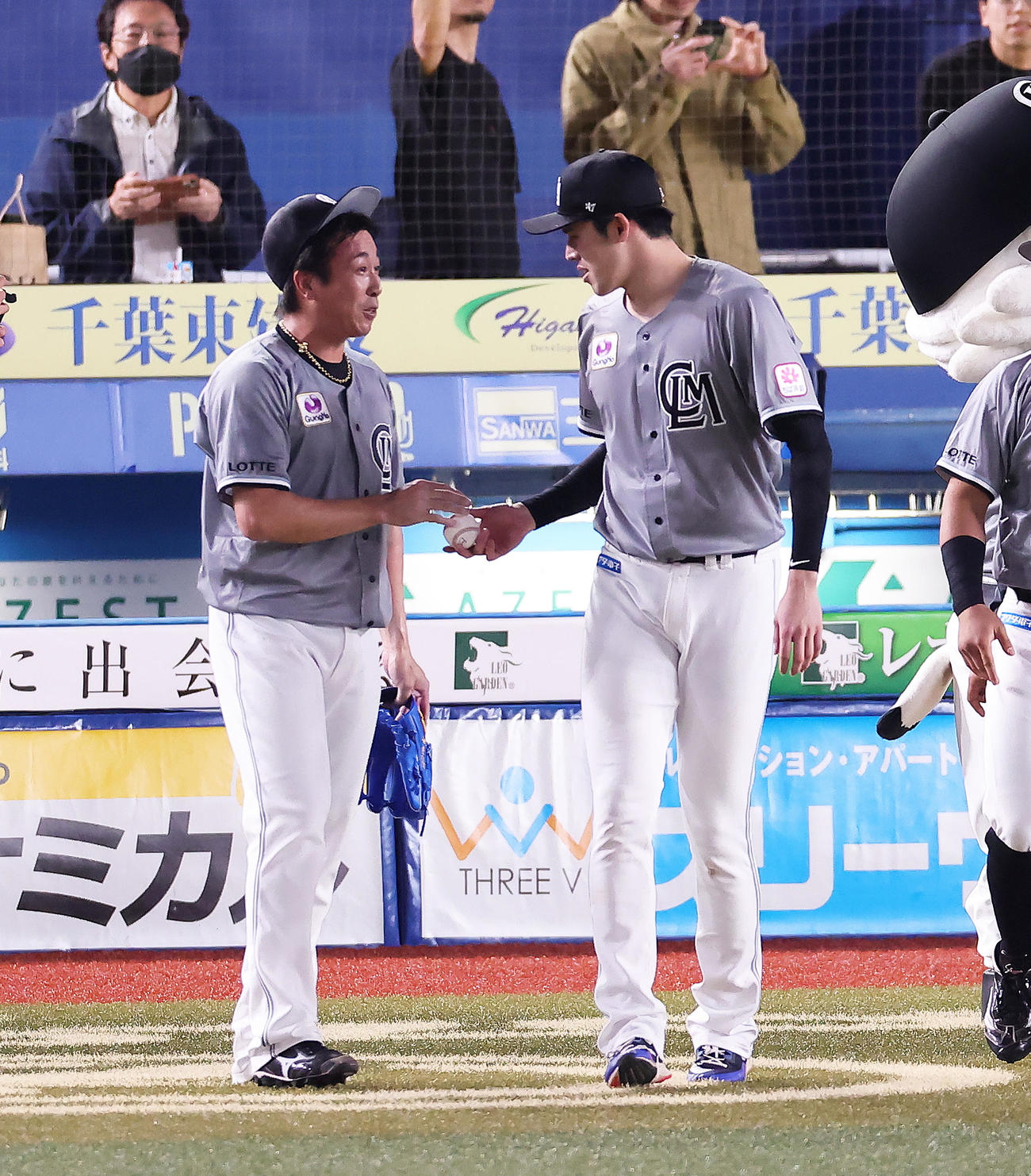 ロッテ対ソフトバンク　ロッテ益田（左）から受け取った勝利球を渡し返す佐々木朗（撮影・足立雅史）