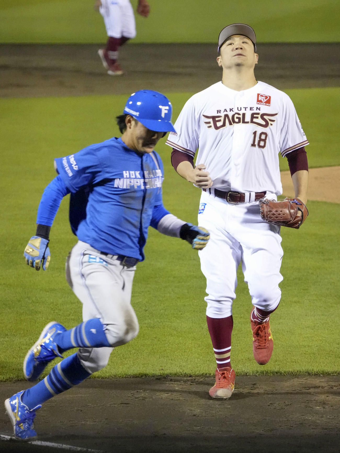 5回日本ハム2死三塁、打者矢沢のとき、暴投で三走奈良間（左）に勝ち越しの生還を許し、天を仰ぐ楽天・田中将（共同）
