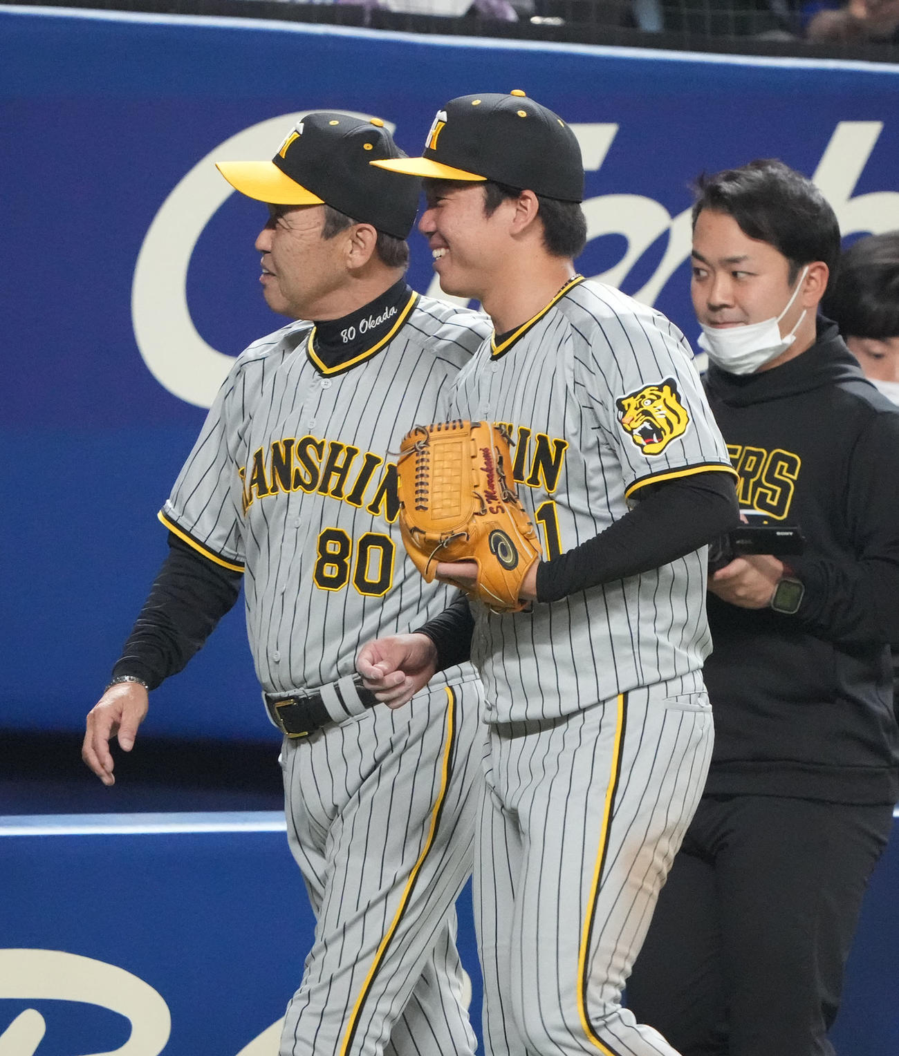 中日対阪神　試合終了、プロ初勝利し岡田監督と明るい表情でベンチへ戻る村上（中央）（撮影・森本幸一）