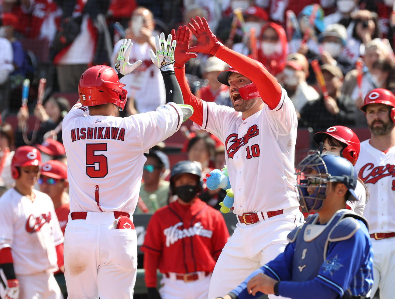広島対DeNA 4回裏広島1死二塁、右越え2点本塁打を放った西川は先制打のマクブルーム（右）に迎えられる（撮影・加藤孝規）