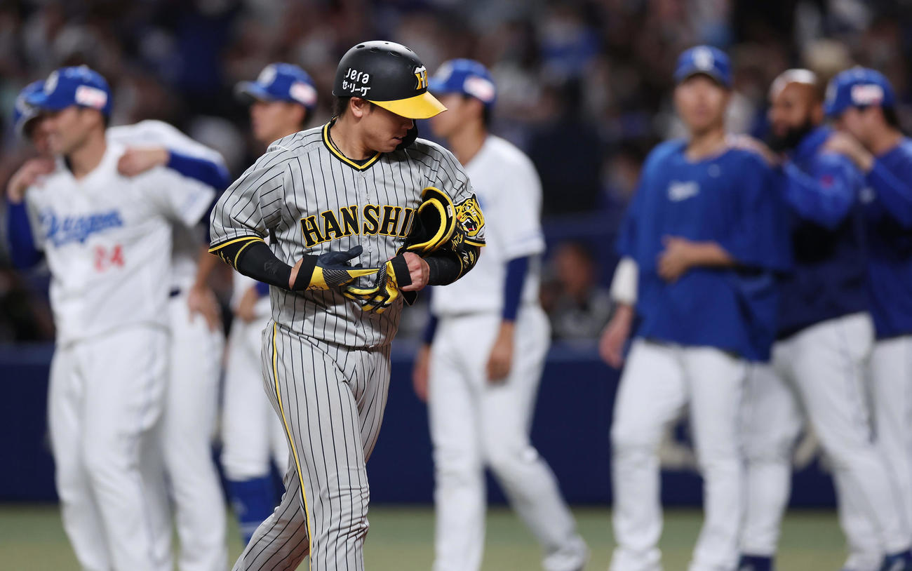 中日対阪神　9回表阪神1死一、二塁、二ゴロ併殺に倒れ試合終了となり、引き揚げる梅野（手前）（撮影・前田充）