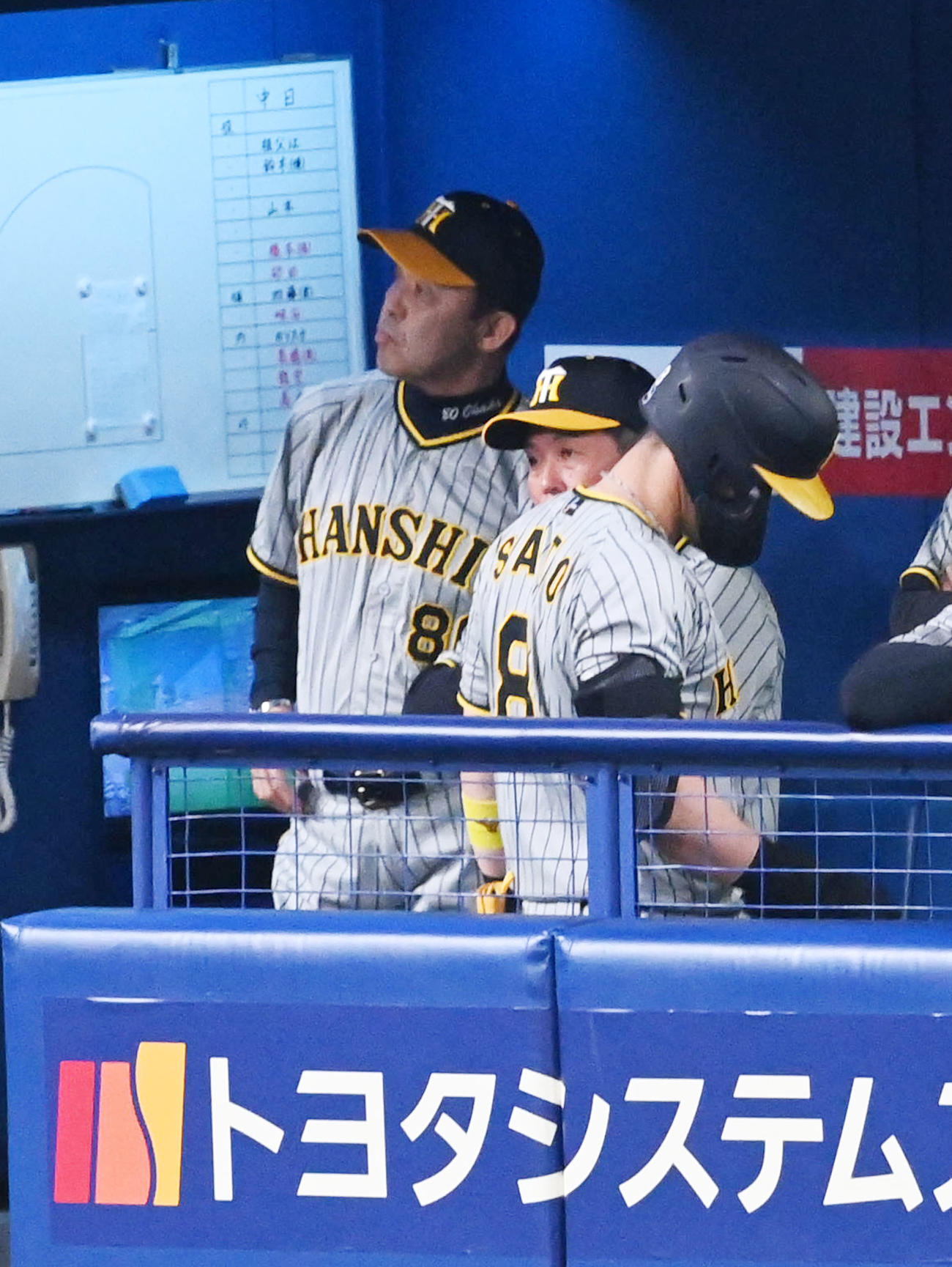 中日対阪神　9回表阪神無死一塁、佐藤輝（右）が右飛に倒れ厳しい表情を見せる岡田監督（撮影・前岡正明）