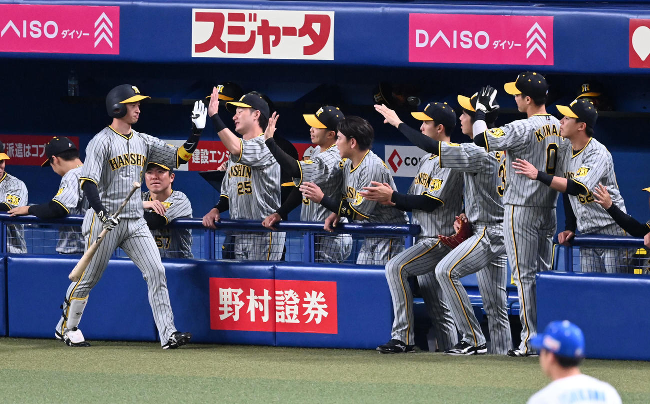 中日対阪神　1回表阪神無死、先頭打者本塁打を放った近本（左）はナインの祝福を受ける（撮影・前岡正明）
