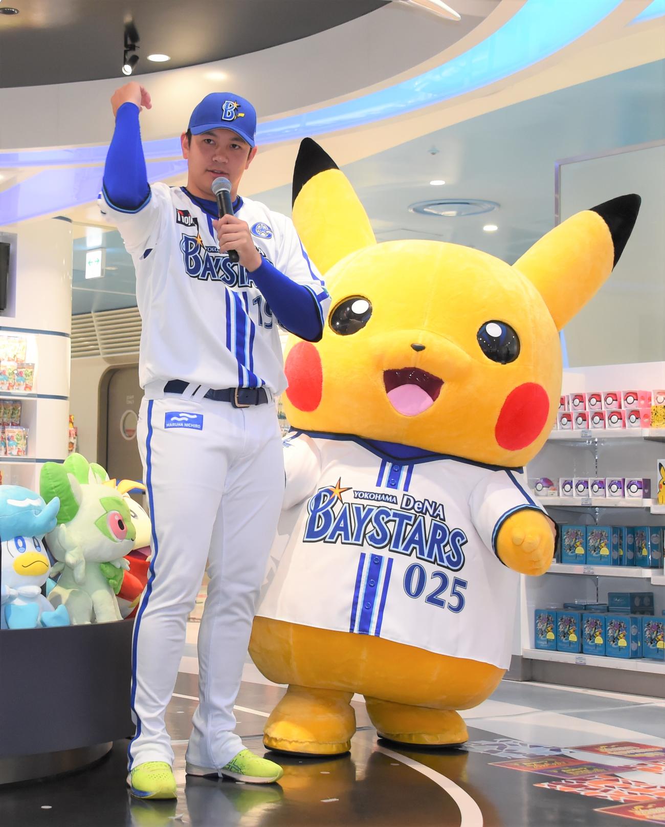 「ポケモンボールパークヨコハマ」開催記者発表会に出席したDeNA山崎はモンスターボールを投げるポーズを取る。右はピカチュウ（撮影・鈴木正章）