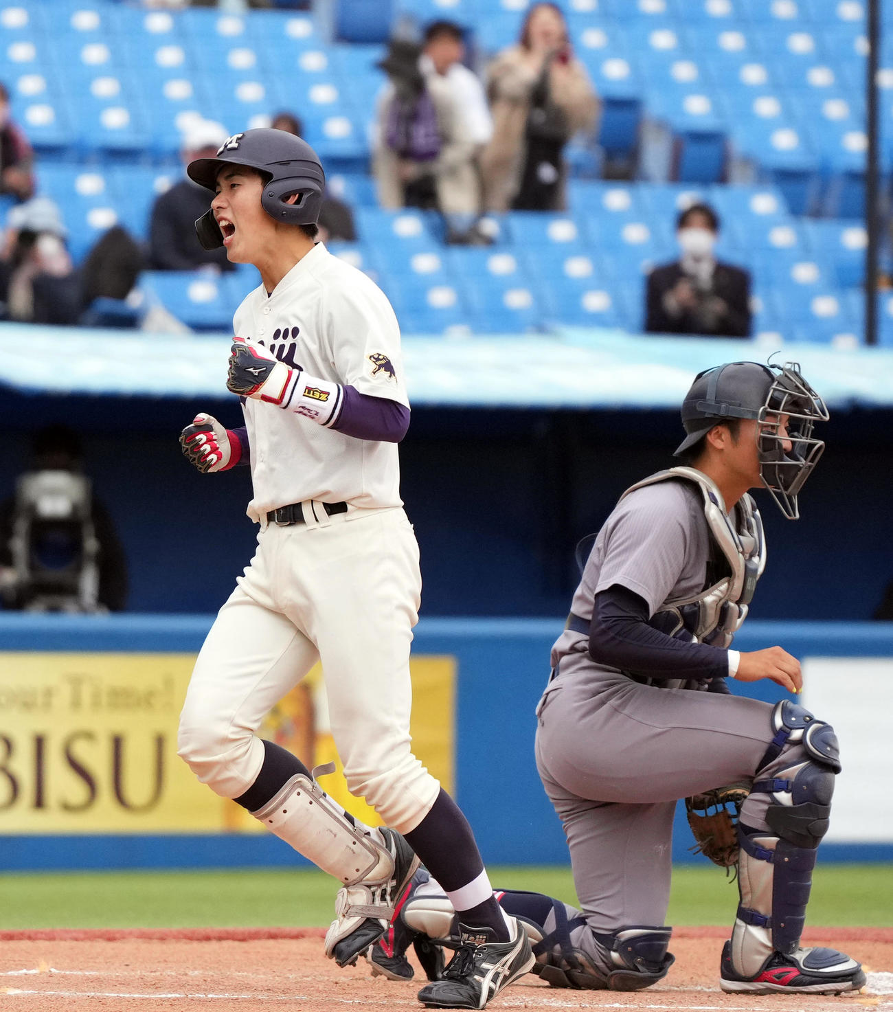 明大対慶大　10回表明大1死一、二塁、3点本塁打を放ち、ほえる明大・小島河（左）。右は慶大・宮崎（撮影・狩俣裕三）