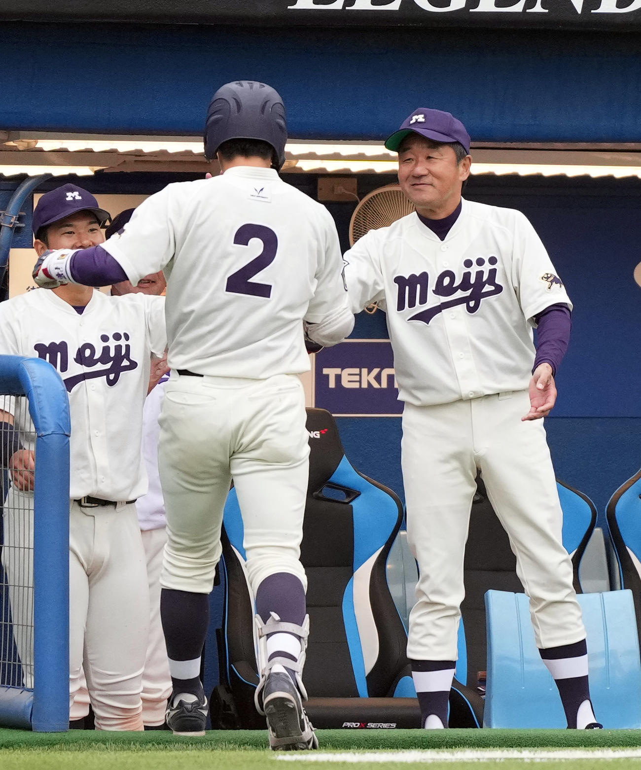 明大対慶大　10回表明大1死一、二塁、3点本塁打を放った明大・小島河（手前）を笑顔で迎える田中監督（撮影・狩俣裕三）