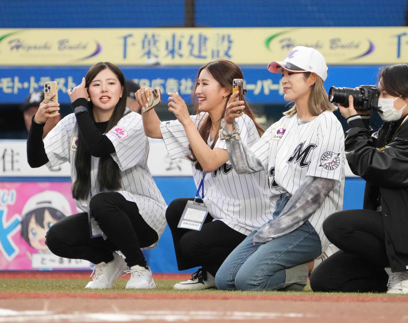 ロッテ対西武で始球式に臨む女子プロゴルファーの金田をスマートフォンで撮影する、右から大西、宇津木（撮影・小沢裕）