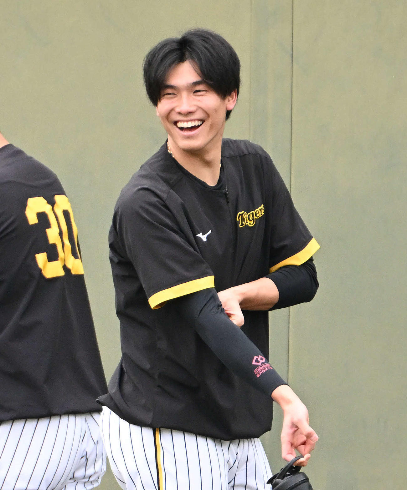 練習中に笑顔を見せる阪神湯浅（撮影・石井愛子）
