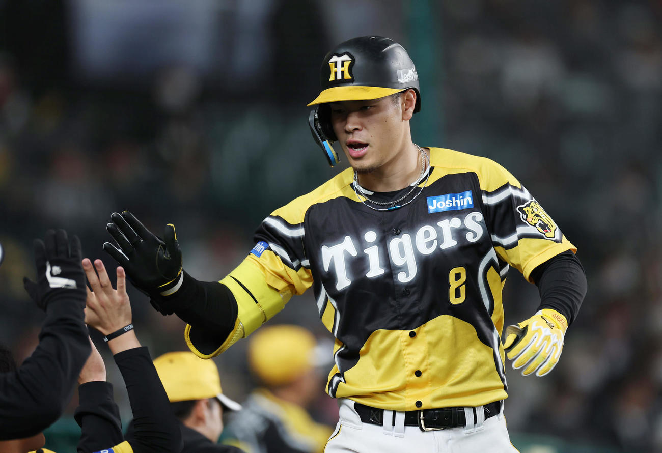 阪神対巨人　5回裏阪神無死、右越えソロ本塁打を放ちナインに迎えられる佐藤輝（撮影・前田充）