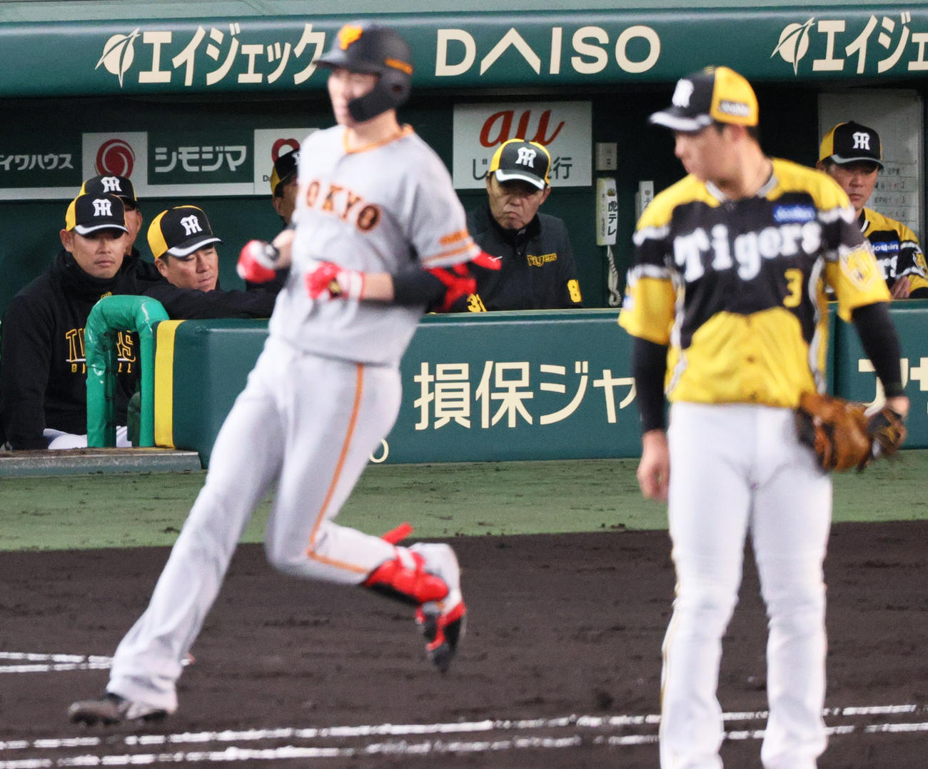 阪神対巨人　3回表巨人2死一、三塁、中前適時打を放った戸郷（手前左）を見る阪神岡田監督（奥中央）（撮影・上山淳一）