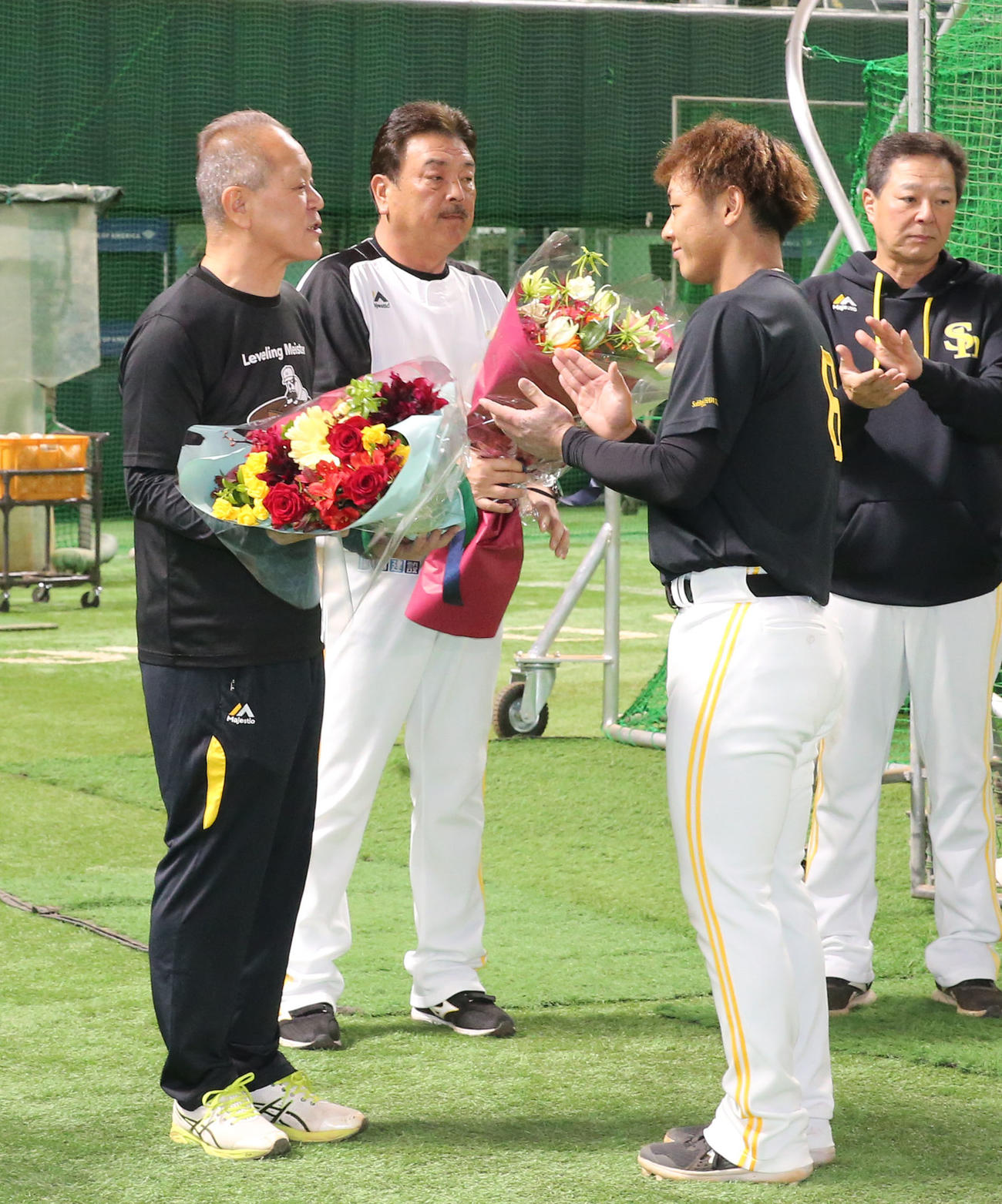 36年間グラウンドを整えた徳永グラウンドキーパーに花束を贈る今宮選手会長、中央は藤本監督（撮影・冨田成美）