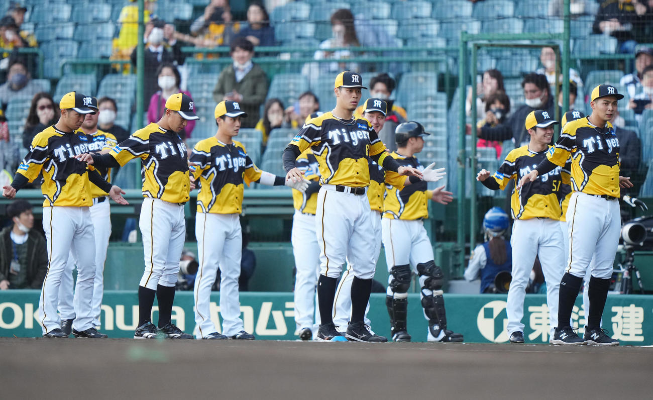 阪神対巨人　「ウル虎イエローユニホーム」を着用し、試合前練習に臨む佐藤輝（中央）ら阪神の選手たち（撮影・江口和貴）