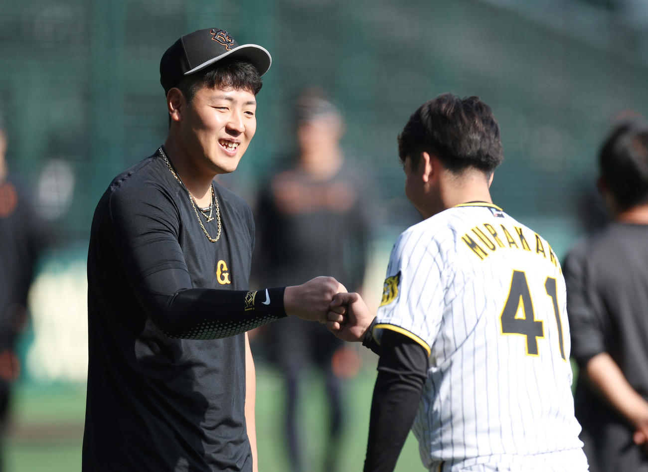阪神対巨人　試合前練習で阪神村上（右）からあいさつされる巨人岡本和（撮影・前田充）