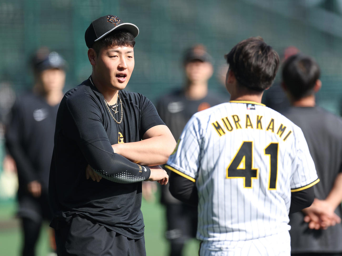 阪神対巨人　試合前練習で阪神村上（右）と言葉を交わす巨人岡本和（撮影・前田充）